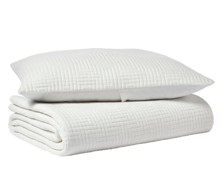 CL-199-9496_6|White quilted coverlet with a distinctive geometric maze pattern, folded neatly with a matching decorative pillow.