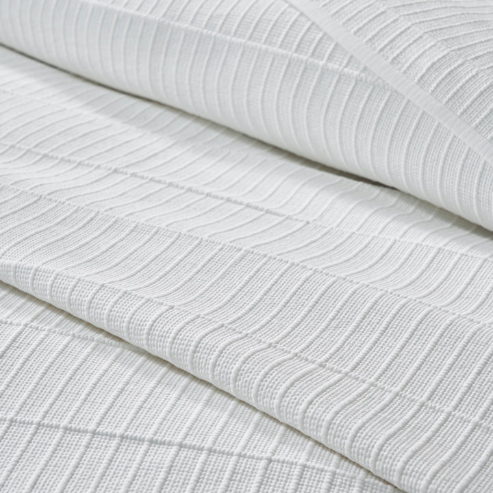 CL-268-9496_6|Detailed close-up of a premium white textured coverlet fabric, showcasing its intricate striped pattern and soft weave.
