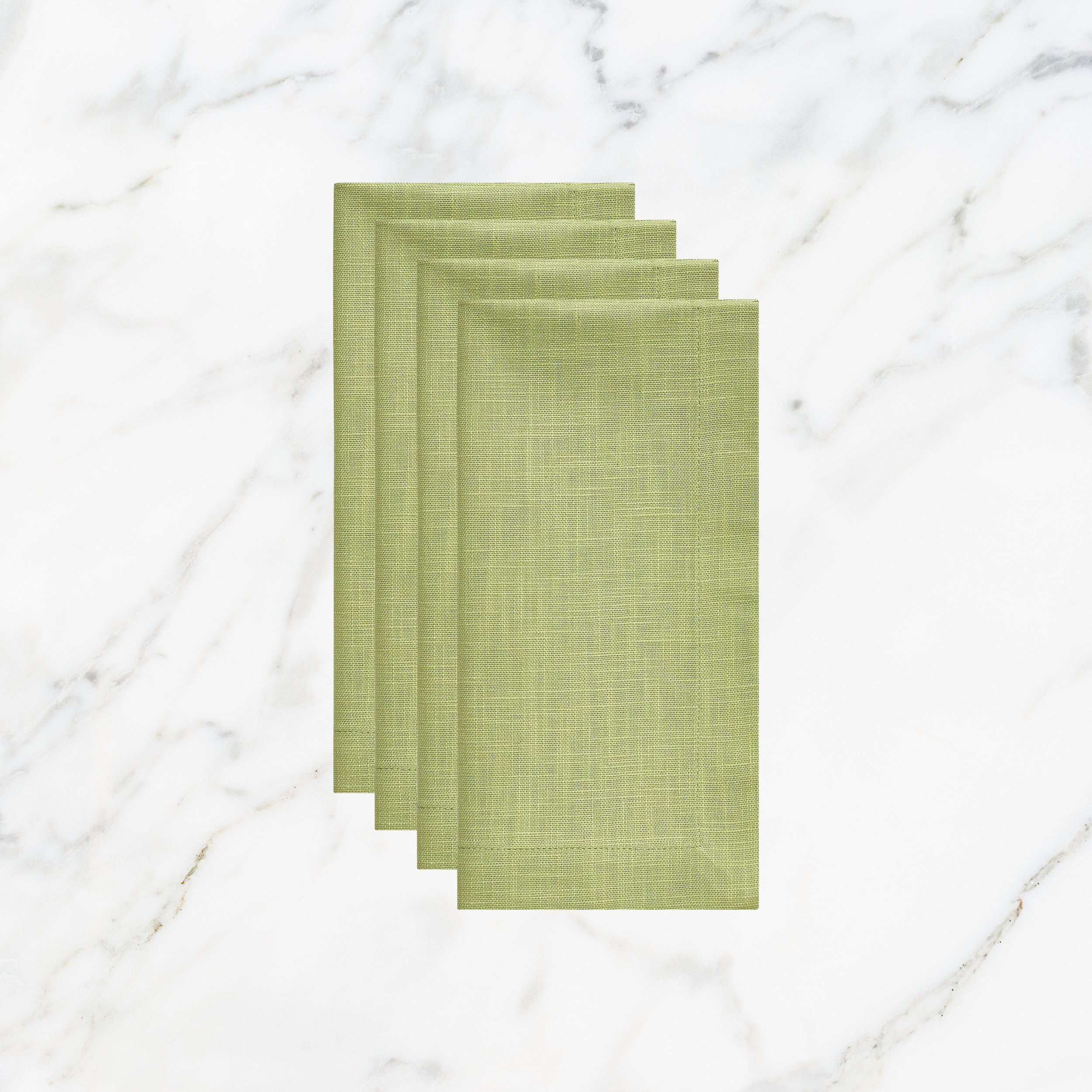 NP-4805-2020_1|Four folded lime green linen-look napkins, elegant table setting accessories on a white marble background. Durable fabric.