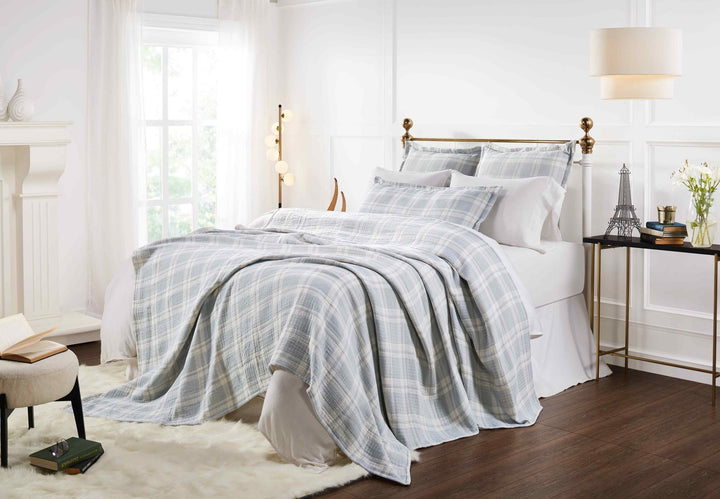 BT-117-9496_5|Light blue and white plaid patterned cotton quilt blanket draped over a bed, creating a cozy and stylish bedroom aesthetic.
