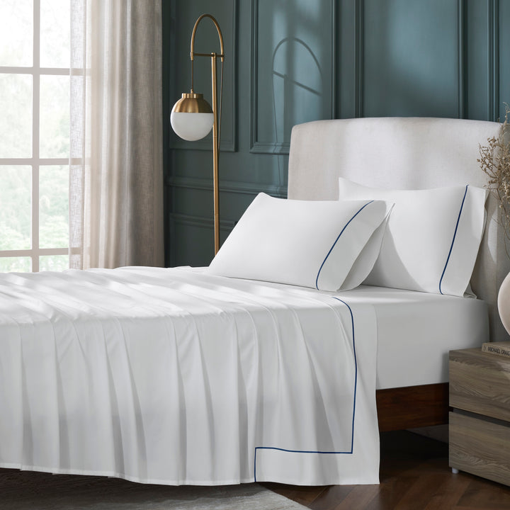 QFL-549-6080_1|Sophisticated white 100% cotton sheets set with delicate navy blue piping, enhancing a luxurious bedroom aesthetic.