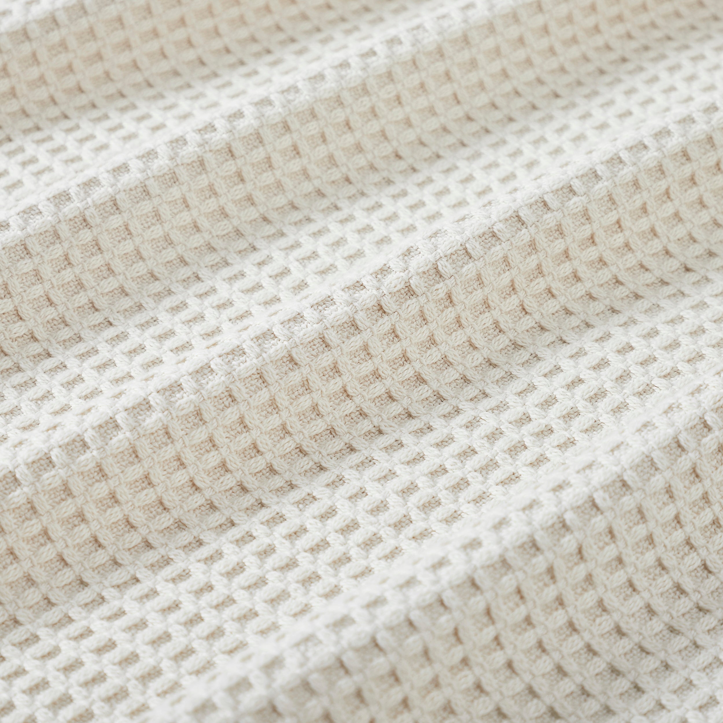 BL-867-11096_4|Close-up of a cozy cream waffle weave blanket texture. Soft, breathable cotton for ultimate comfort and home decor accent.