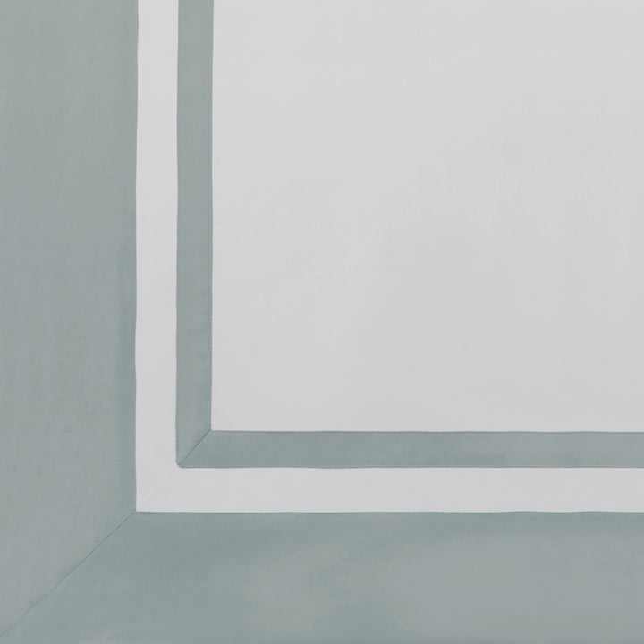 AKP-541-2040_5|Close-up of a white 100% cotton sateen flat sheet with a wide light blue border and a thinner white inner border.