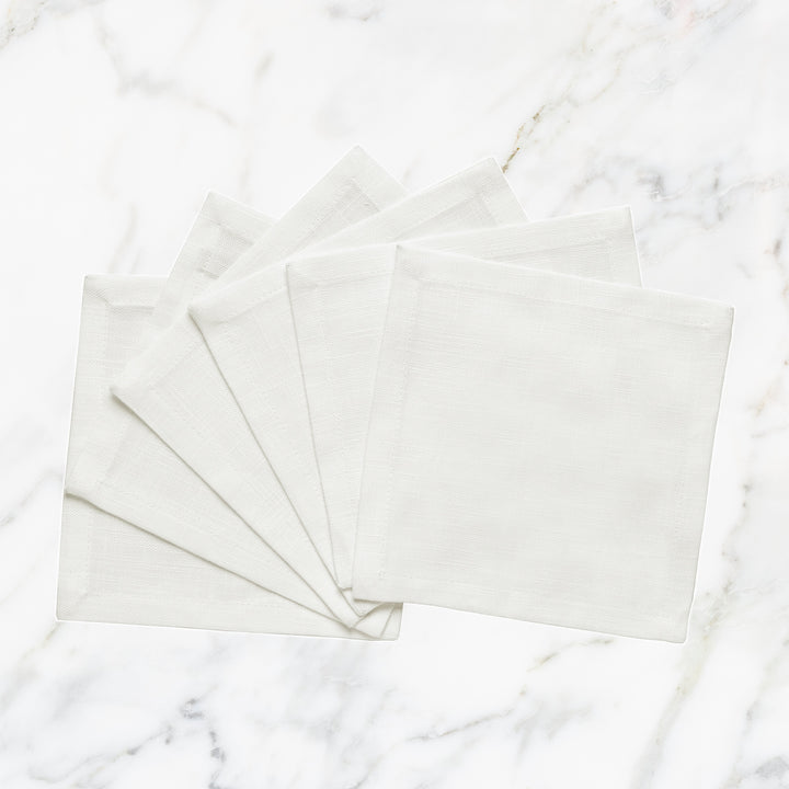 CNP-4908-66_1|Set of fanned white linen napkins displayed on a pristine white marble background for elegant table settings.