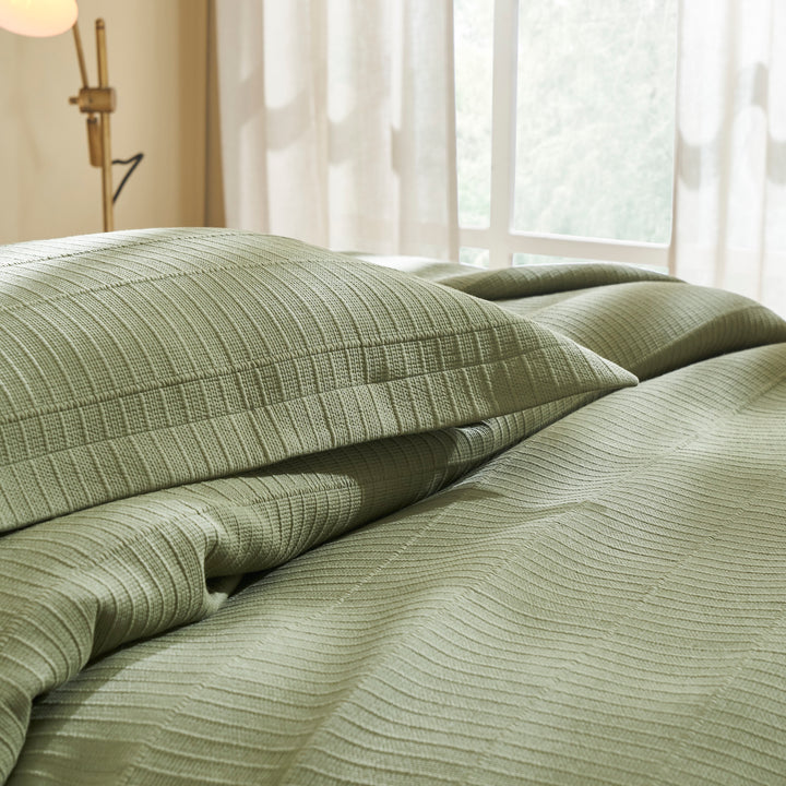 CL-270-9496_7|Close-up of sage green textured cotton blend coverlet and pillow shams, highlighting woven stripe fabric detail.