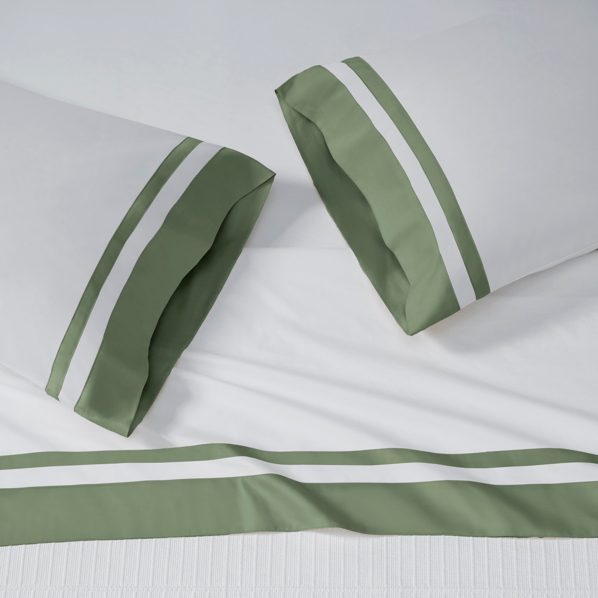 AKP-542-2040_2|White 100% cotton sateen sheet set with two pillowcases and a flat sheet, each featuring wide olive green and white striped borders.