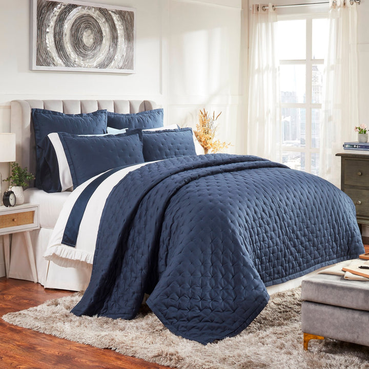 QT-357-11096_2|Elegant navy blue quilted quilt set drapes beautifully on a bed in a bright, stylish bedroom with natural light.