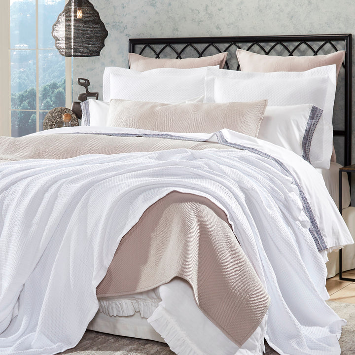 BL-855-9496_1|Elegant white waffle weave blanket layered with a cozy light pink throw on a stylish bed, perfect for a modern bedroom.