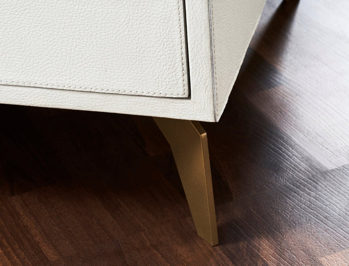 FN-5201-262028_6|Close-up of sleek gold tapered leg on a white shagreen nightstand. Modern design, stable furniture base.