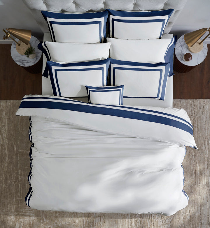 DT-069-9092_3|Overhead view of a bed with a neatly folded white duvet cover, prominent navy blue border details, and matching pillow shams.