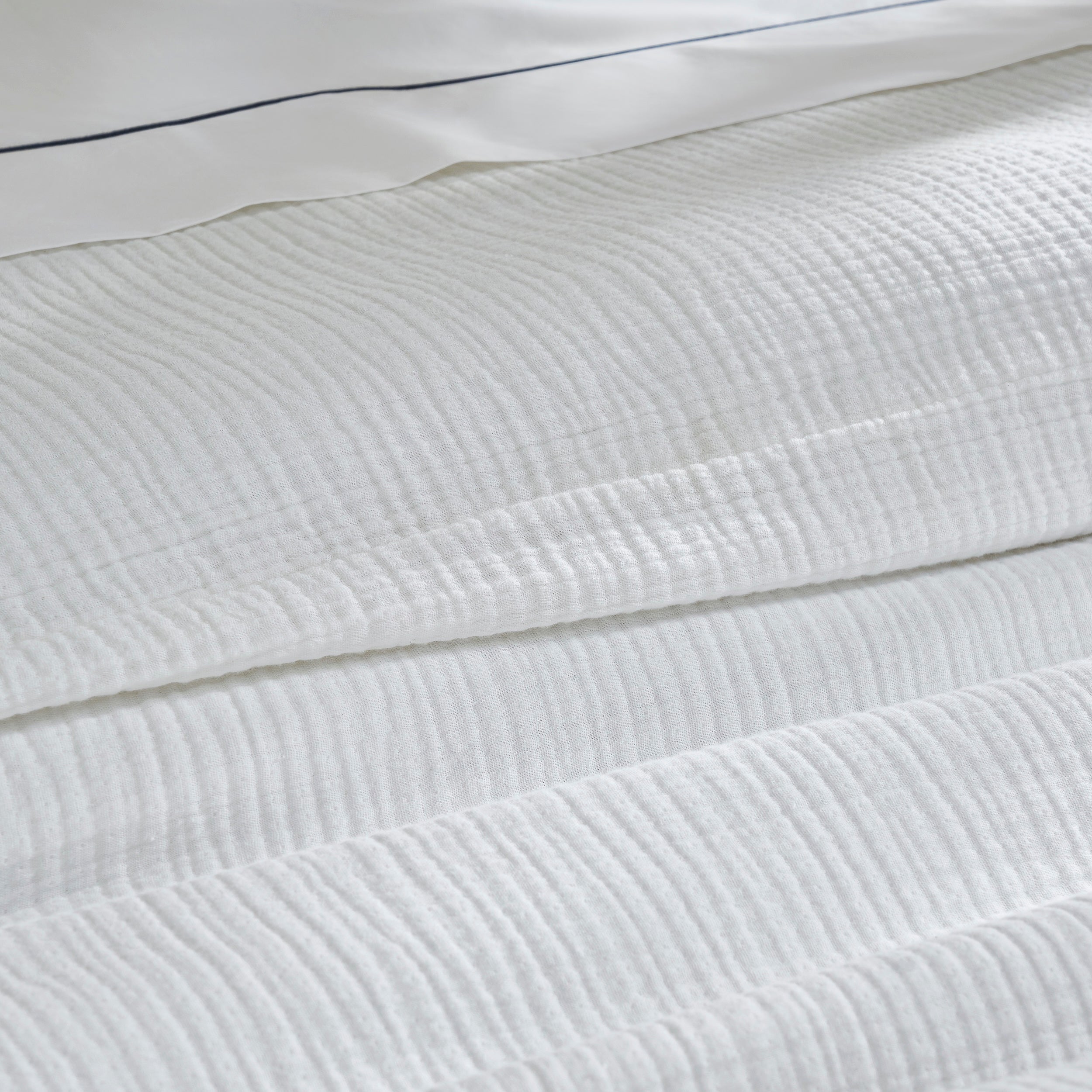DT-048-10692_7|Detailed close-up of the white crinkled cotton gauze duvet cover texture, highlighting its soft, inviting feel. Premium bedding.