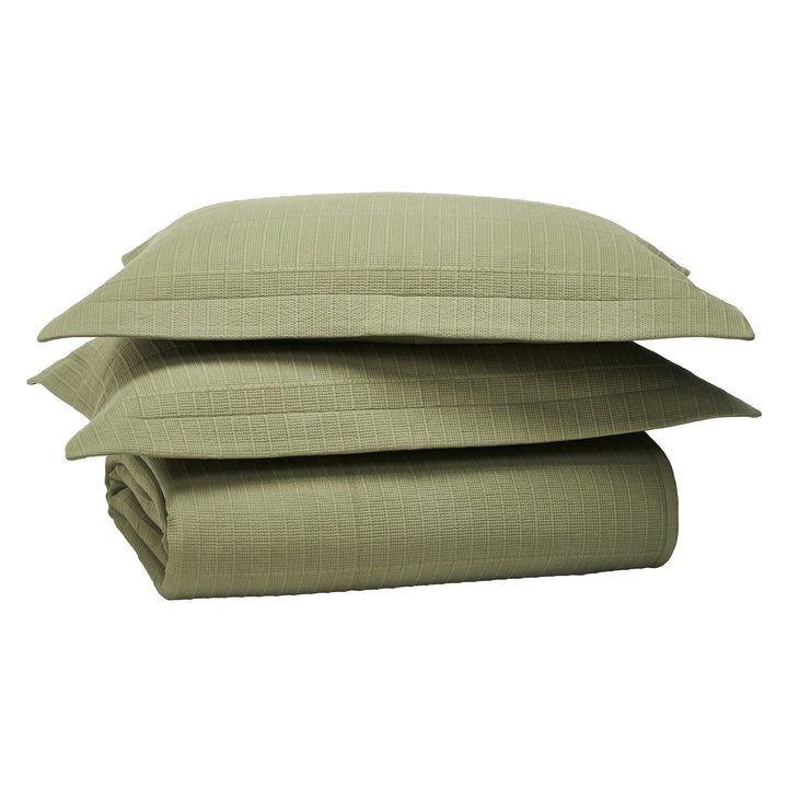 SS-270-2026_4|Stack of sage green coverlet and two pillow shams, showcasing its soft ribbed texture and elegant striped design.