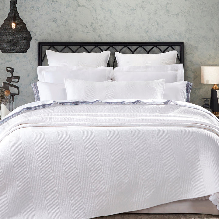 CL-170-9496_1|Elegant white coverlet with a distinct chevron woven pattern adorning a luxurious bed, enhancing modern bedroom decor.