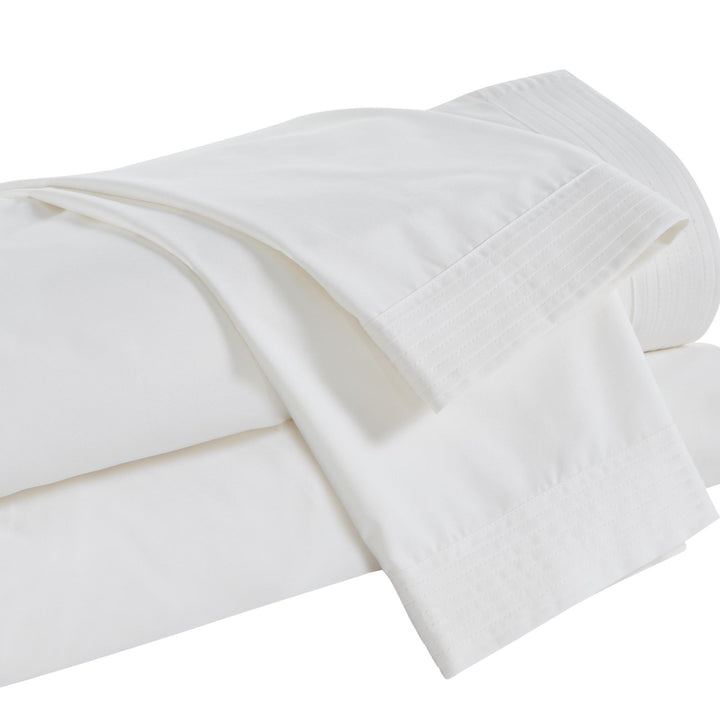QSS-522-6080_5|Neatly folded crisp white 100% cotton sheets with elegant pleated details. Experience breathable, luxurious comfort.