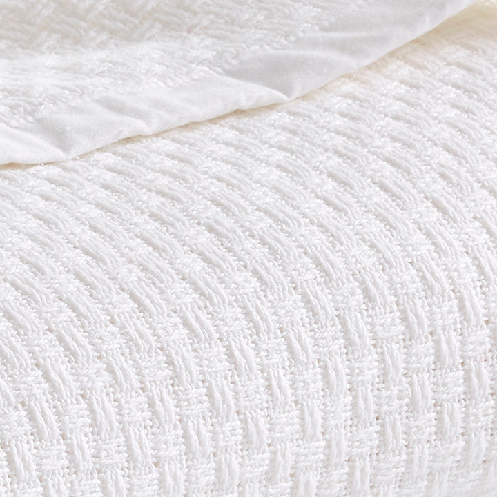 BL-852-9496_4|Detailed close-up of a luxurious white waffle weave blanket, highlighting its intricate texture and soft comfort.