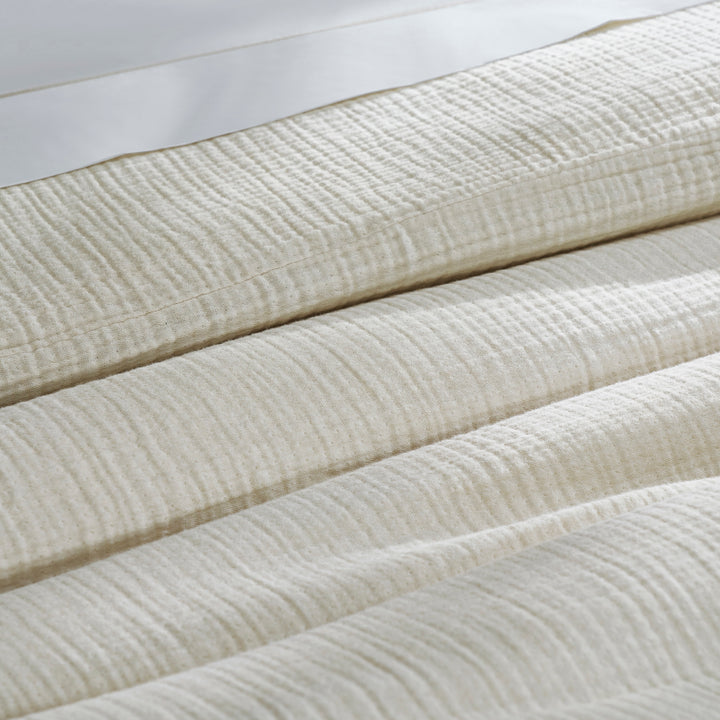 DT-049-10692_7|Folded light cream textured organic cotton gauze duvet cover, showcasing its soft, breathable, and crinkled fabric detail.