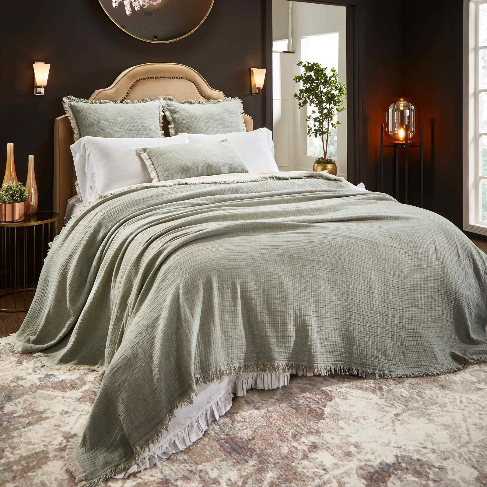 BT-109-9496_1|Stylish sage green crinkled blanket with frayed edges draped over a bed, creating a relaxed, bohemian bedroom aesthetic.