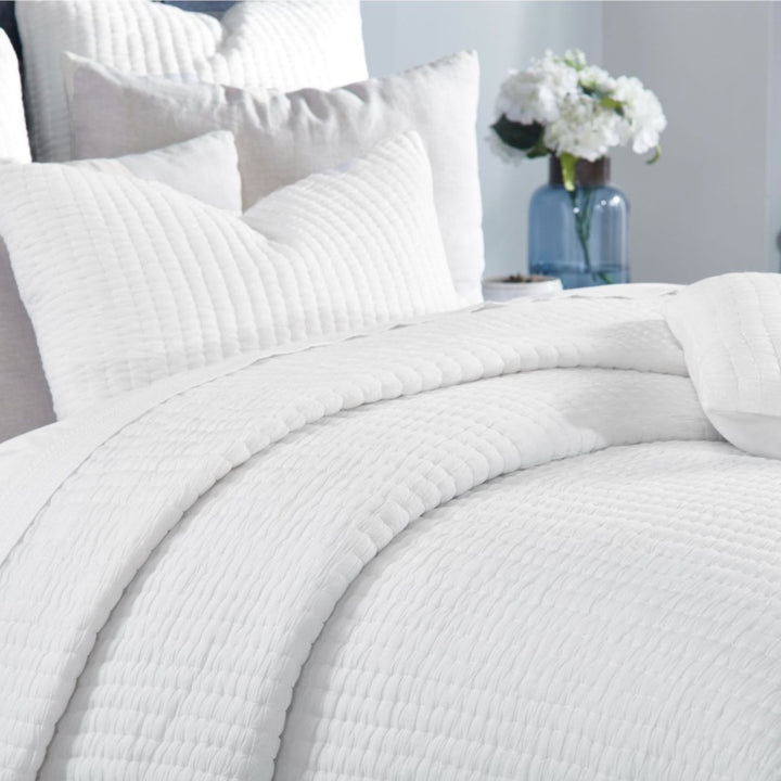 QT-358-9496_4|Close-up of a luxurious white quilted blanket with subtle textured stripes, showcasing comfort and pristine elegance.