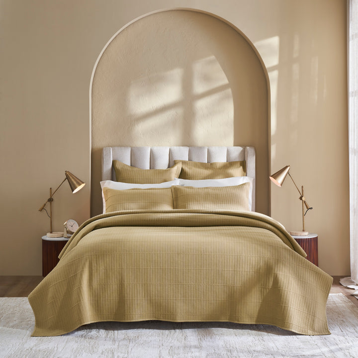 CL-269-11096_2|Gold beige textured quilted coverlet on a bed with matching pillows, enhancing an elegant bedroom's warm ambiance.