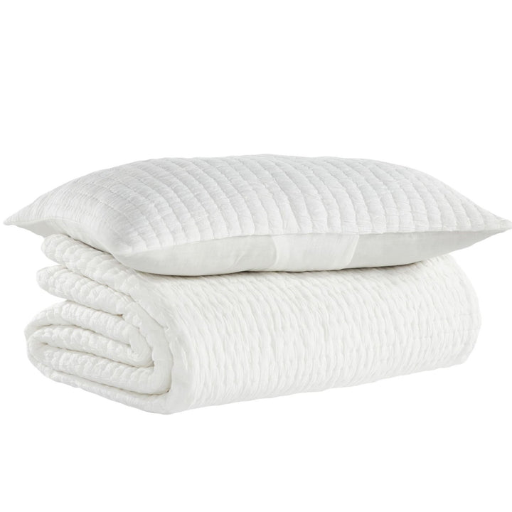QT-359-9496-LOT1_8|Stacked white textured quilt and matching pillow sham for a cozy bedroom, featuring soft, inviting fabric and modern design.