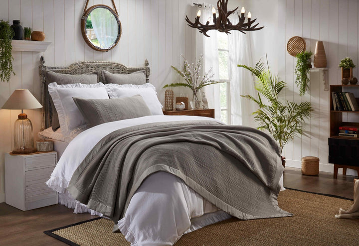 CL-162-9496_2|Gray textured coverlet draped over a white bed in a rustic bedroom, adding cozy layering and a touch of elegance.