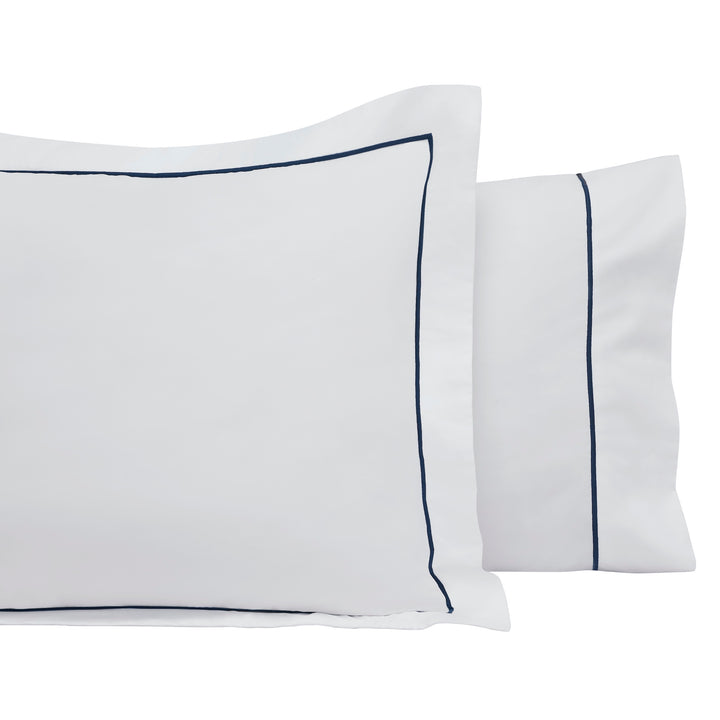 AKP-549-2040_3|Luxurious 100% cotton sheets: crisp white pillow shams with elegant navy blue piping. Premium soft bedding for comfort.