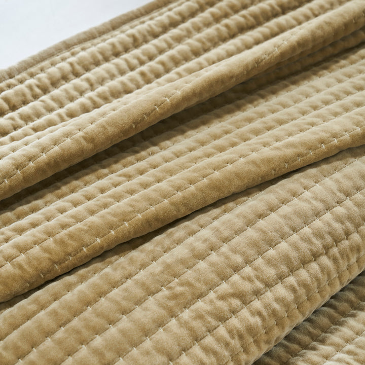 CL-267-11096_6|Close-up of a folded tan quilted velvet coverlet, highlighting its plush texture and detailed horizontal stitching.