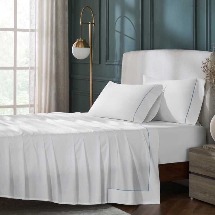 TFL-530-3980_1|Luxurious 100% cotton white sheet set with elegant light blue piping, styled on a bed for a serene bedroom aesthetic.