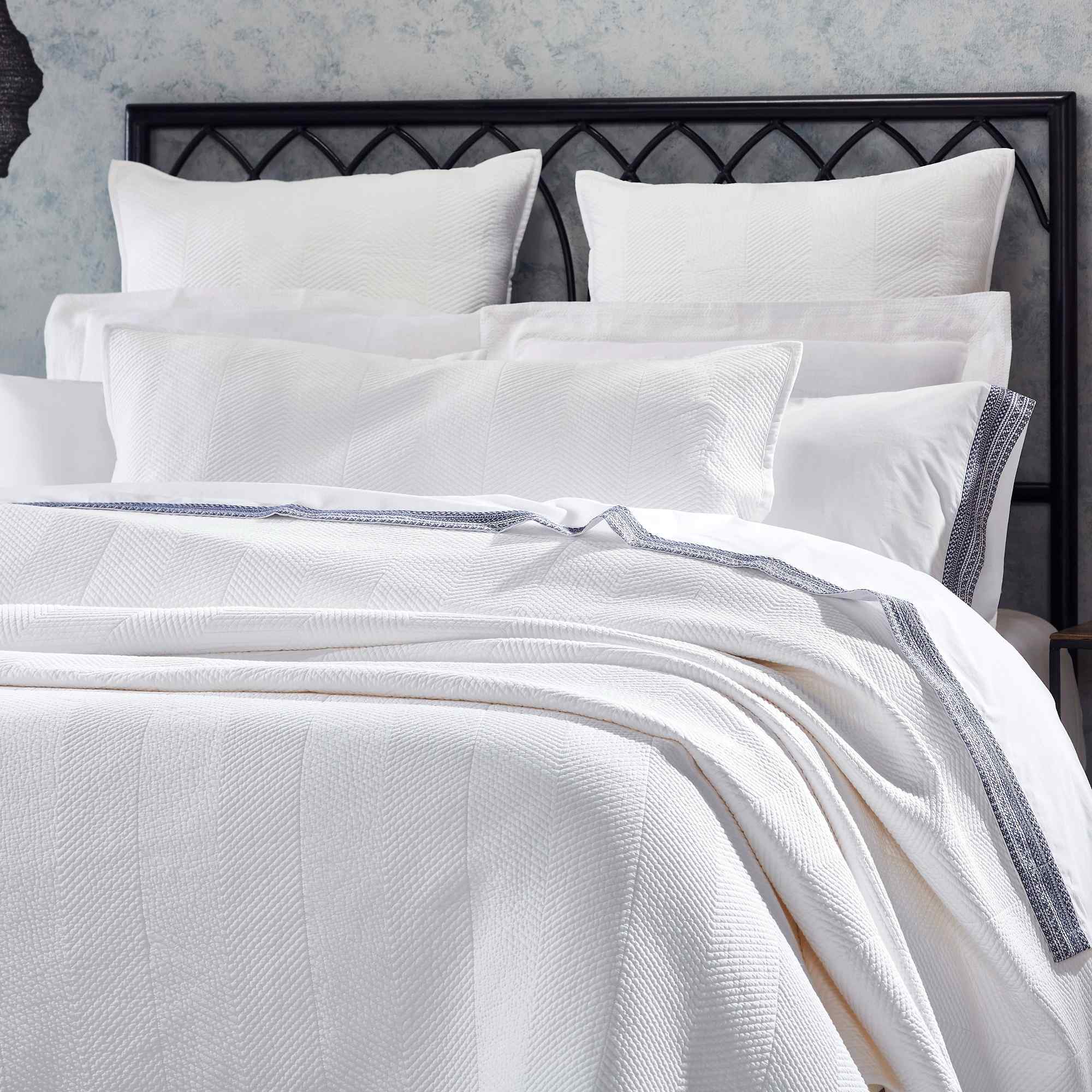 CL-170-11096_3|Close-up of elegant white chevron woven coverlet on a plush bed, showcasing its textured pattern and sophisticated design.