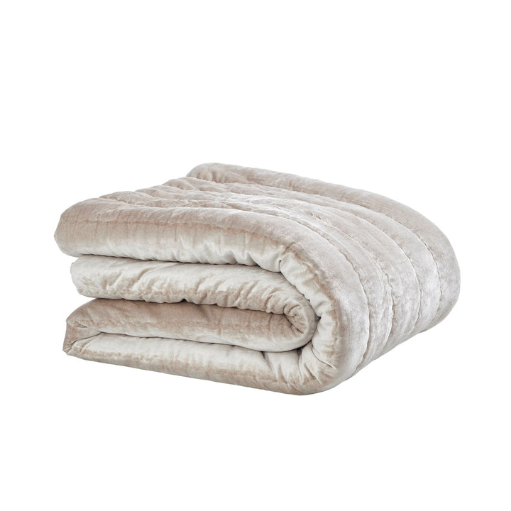QT-339-9496_4|Beautifully folded champagne velvet channel-quilted quilt, highlighting its plush texture and inviting design for cozy warmth.