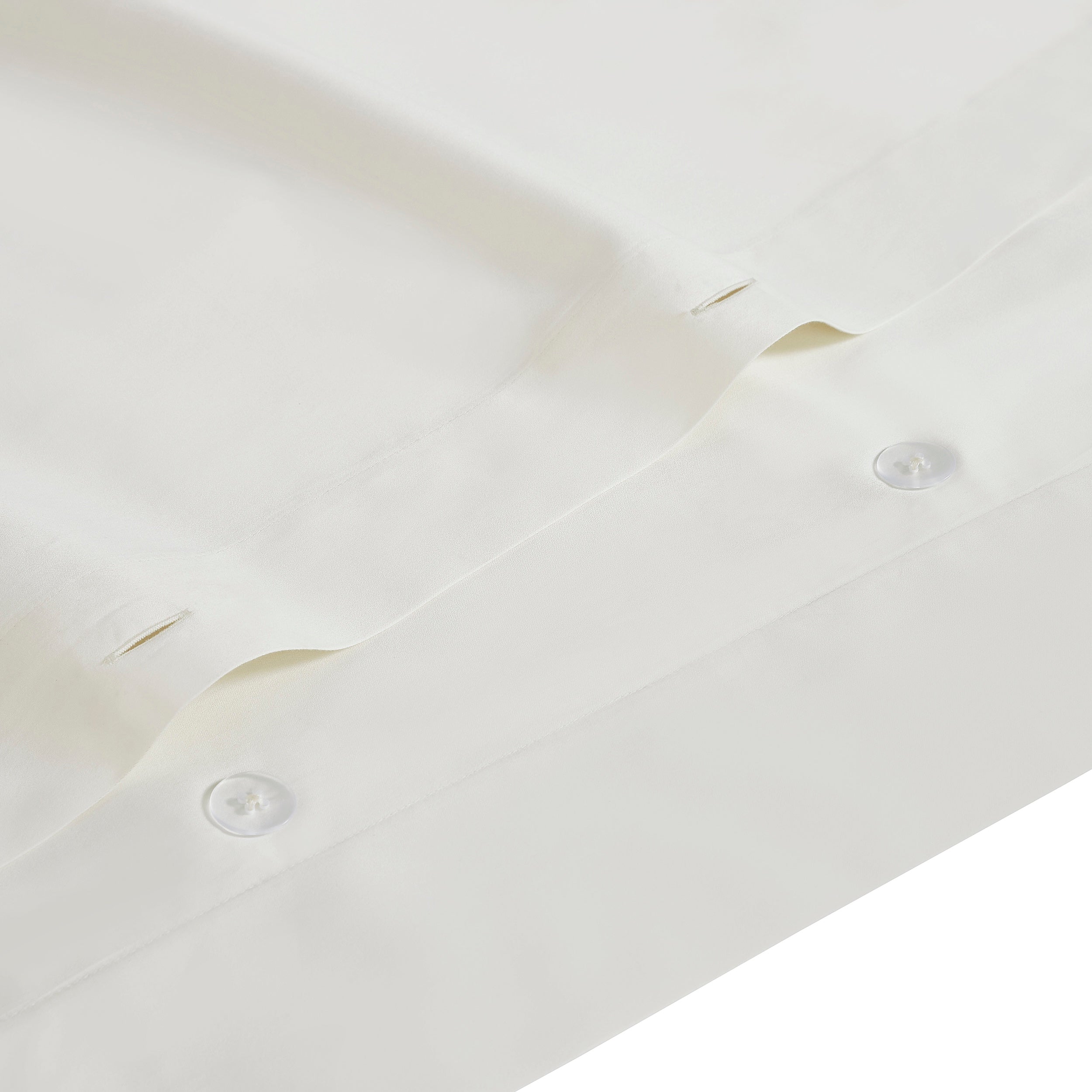 DT-064-10692_4|Crisp white duvet cover detail featuring hidden button closure. High-quality fabric for a neat, elegant finish.