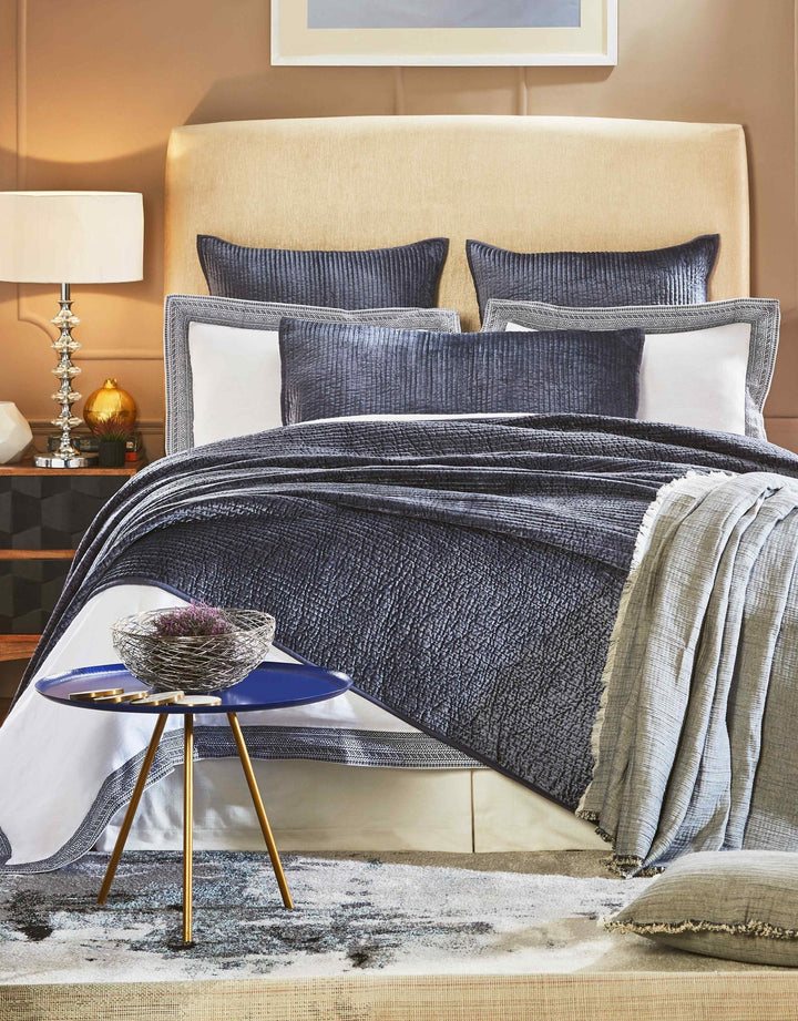 CL-159-9496_1|Dark blue quilted coverlet with a textured, ribbed pattern on a bed in a stylish modern bedroom setting.