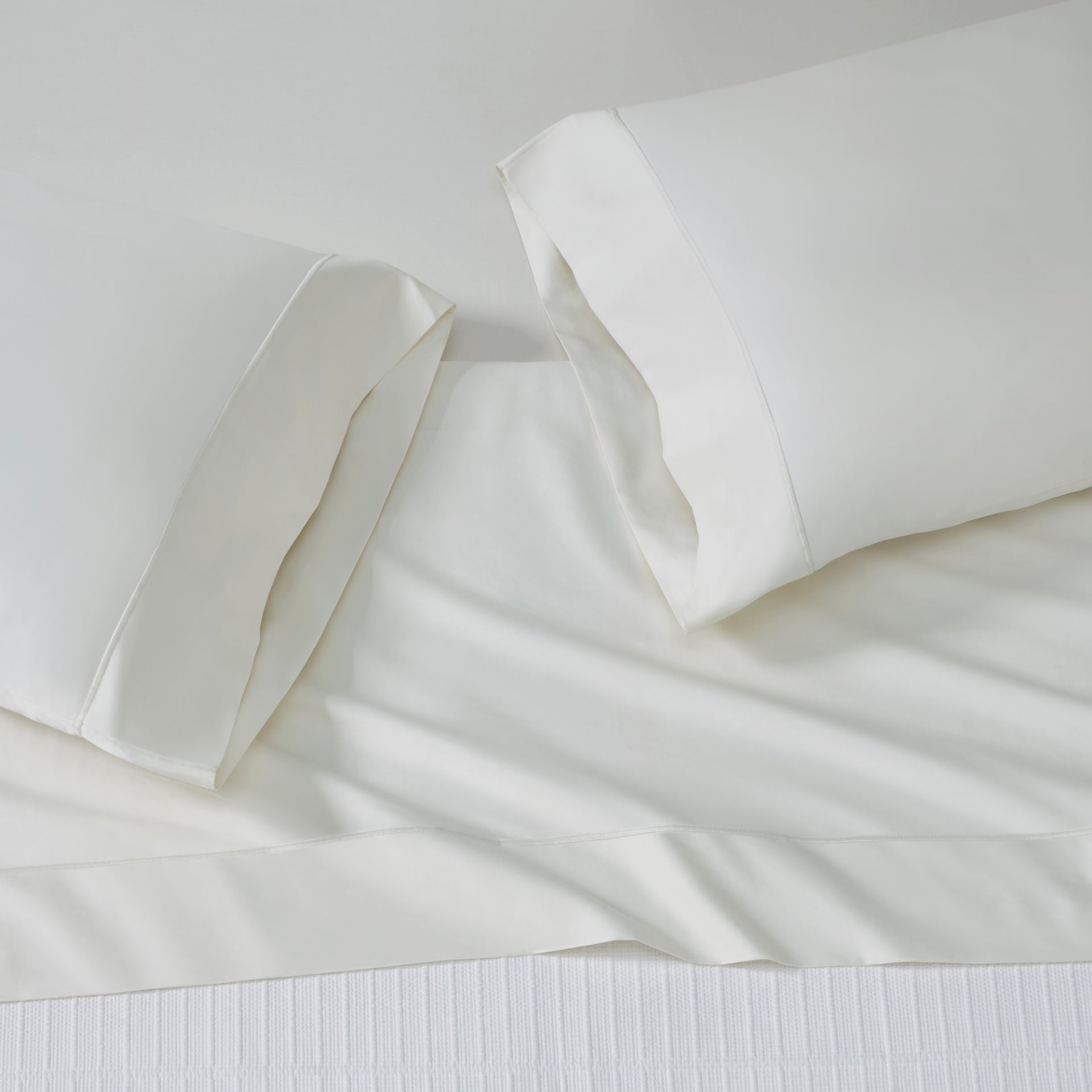 ASP-546-X_2|White 100% cotton sateen sheet set on a bed, featuring a flat sheet and two hemmed pillowcases, smooth finish.