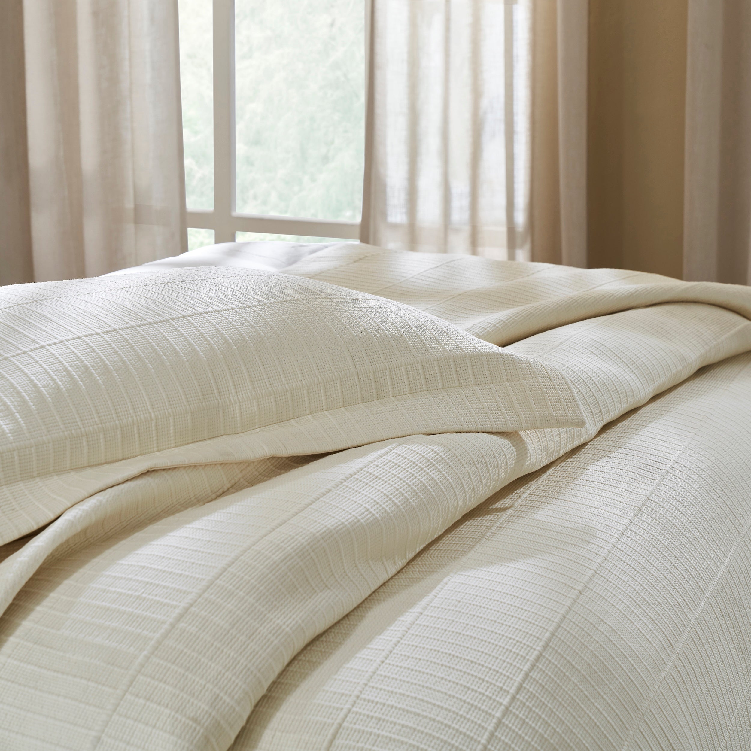 ES-271-2626_3|Elegant cream textured coverlet and pillow on a bed, showcasing sophisticated woven design for modern bedroom decor and cozy sleep.