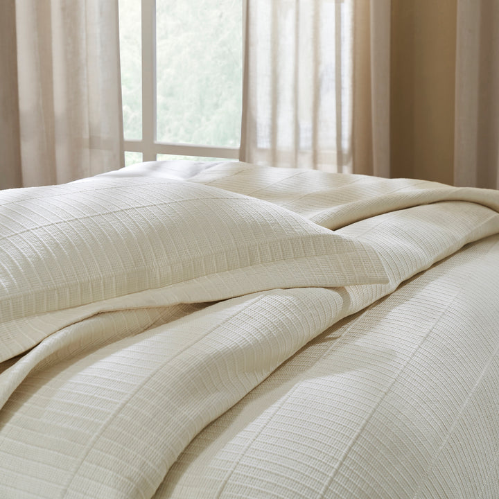 ES-271-2626_3|Elegant cream textured coverlet and pillow on a bed, showcasing sophisticated woven design for modern bedroom decor and cozy sleep.
