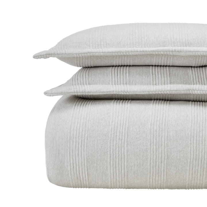 DT-044-9092_5|Stacked light grey ribbed duvet cover and two textured pillow shams, offering cozy comfort and modern style for any bedroom.