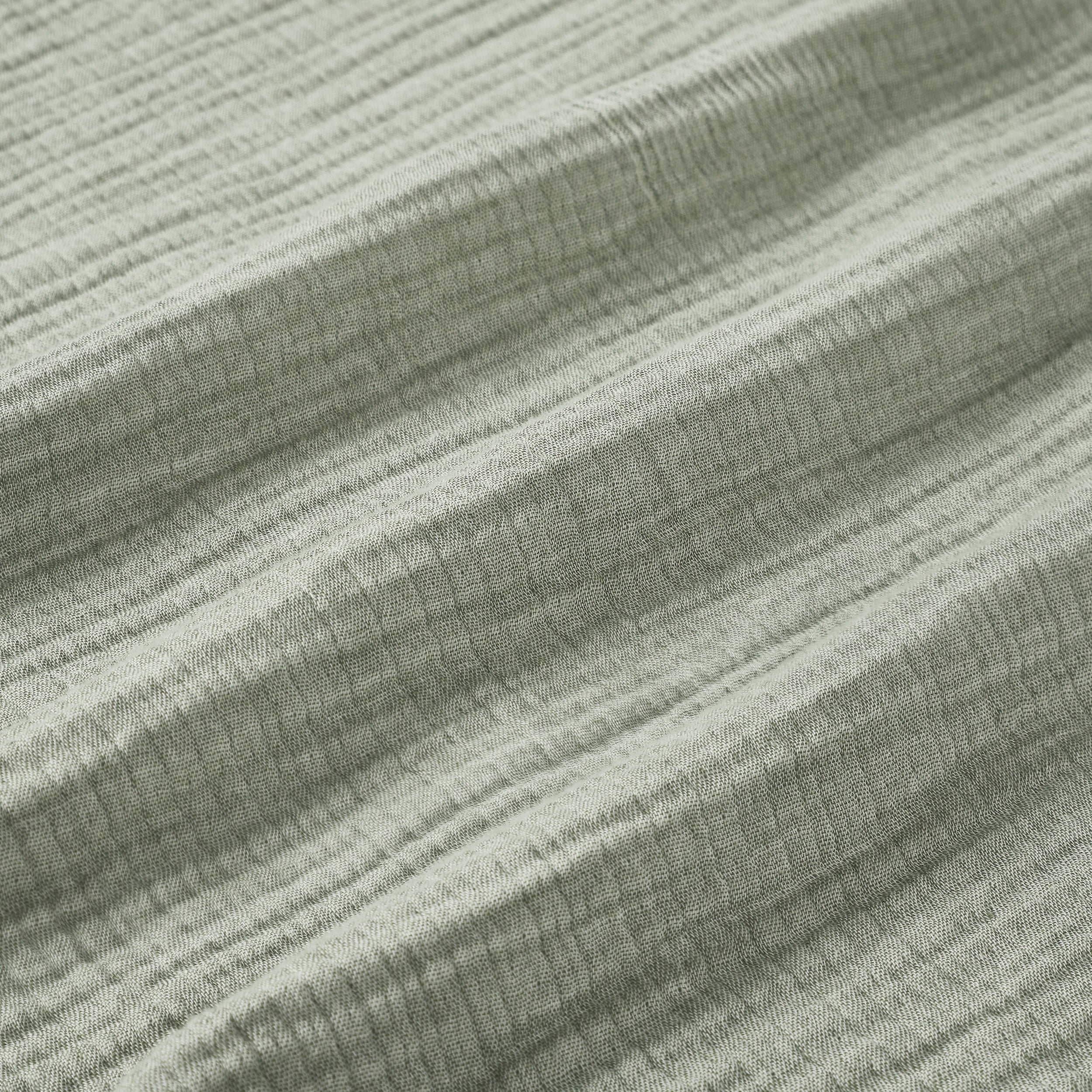 BL-864-9496_9|Detailed close-up of a soft sage green textured blanket, highlighting its cozy crinkled fabric and natural fibers.