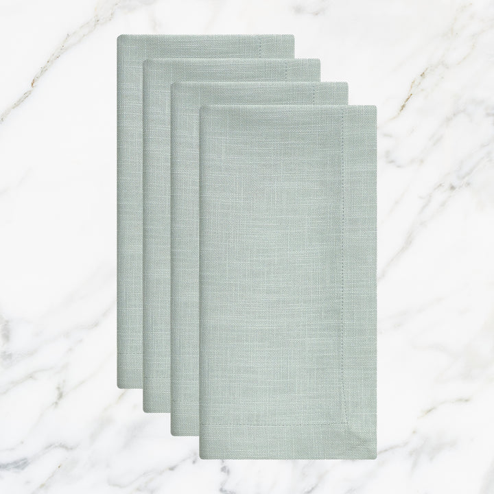 NP-4806-2020_1|Four folded light blue linen-look napkins, elegant table setting accessories on a white marble background. Durable fabric.