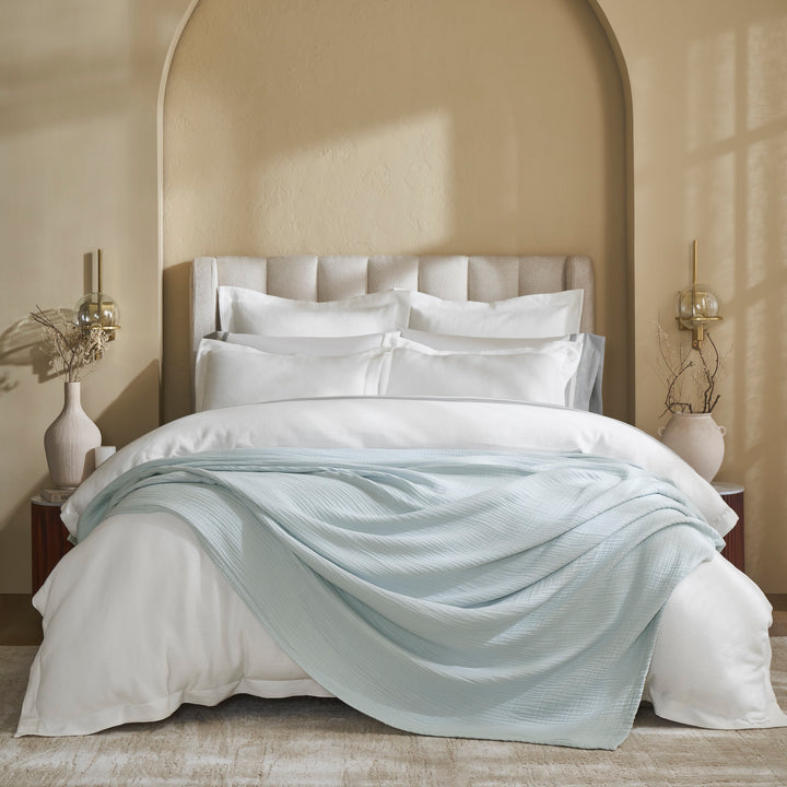 BL-863-9496_1|Light blue 100% cotton gauze blanket draped on a bed with white bedding, soft, breathable, cozy bedroom decor.