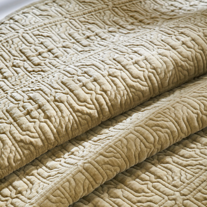 QT-377-9496_6|Close-up of a folded plush tan quilt, showcasing its intricate geometric pattern and soft, textured fabric for cozy comfort.