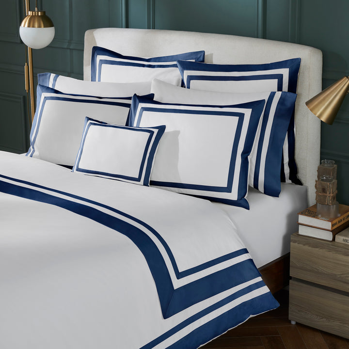 DT-069-6886_2|White duvet cover with navy blue double border stripe, luxurious bedroom setting, crisp white and blue bedding ensemble.