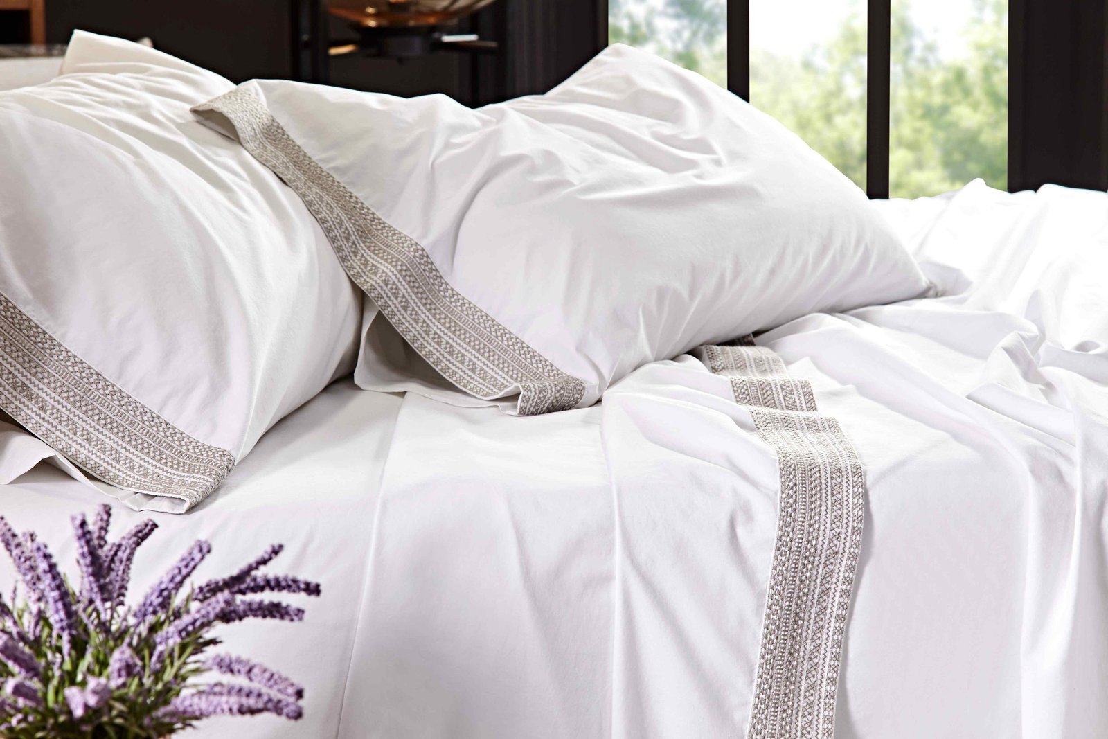 CSS-501-7284_4|Close-up of crisp white 100% cotton sheets and pillowcases with elegant woven grey trim, for a comfortable bed.
