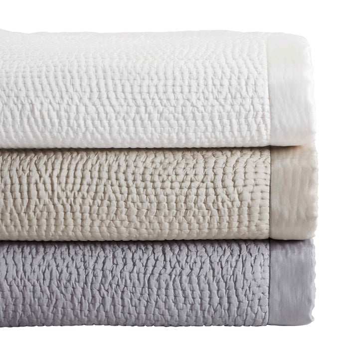 CL-166-11096_6|Stack of three folded textured coverlets in off-white, beige, and grey with a small, uniform waffle-like quilting pattern.