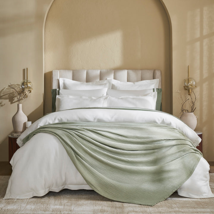 BL-864-11096_1|Sage green gauze blanket draped elegantly on a bed, soft and breathable, perfect for a cozy, stylish bedroom aesthetic.