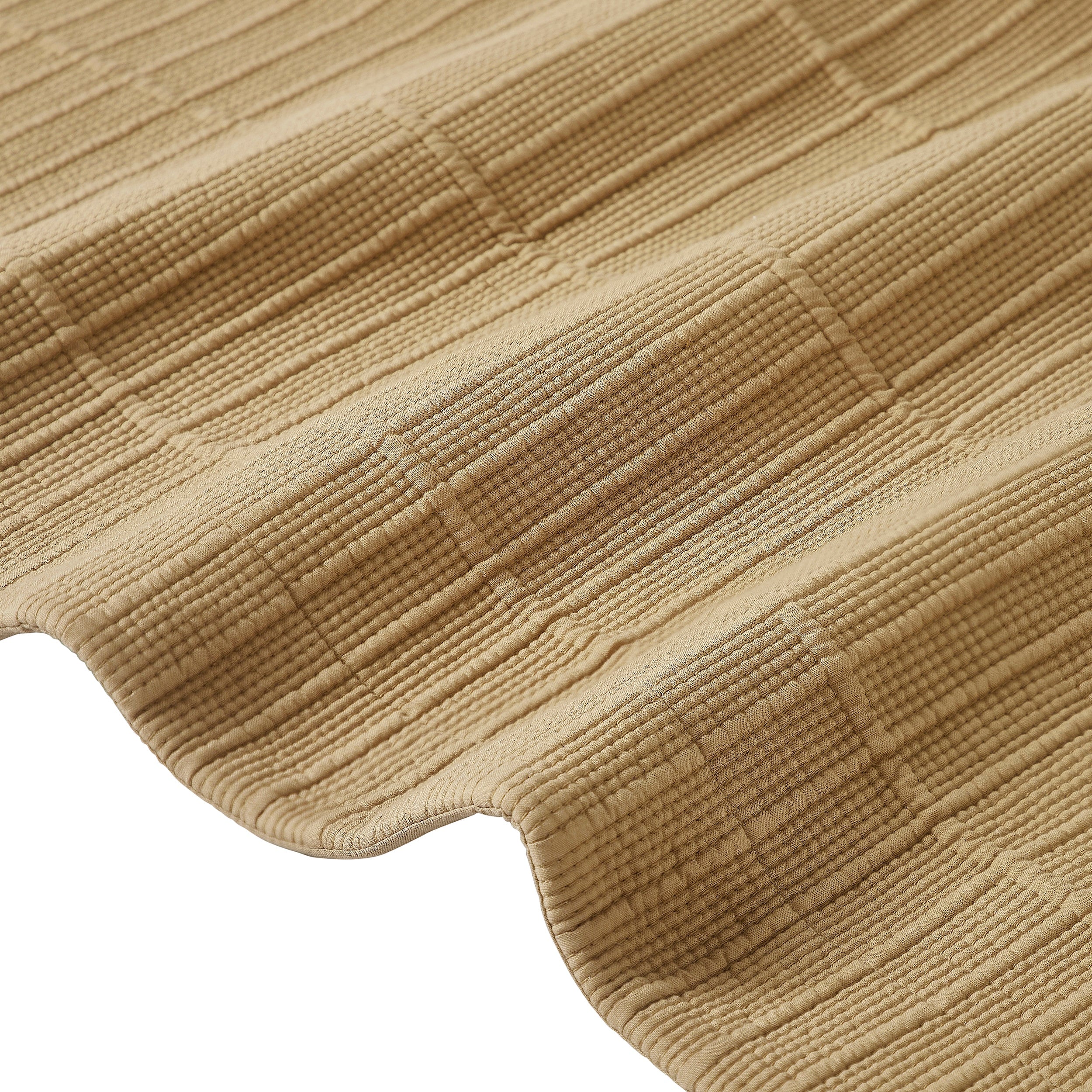 CL-269-9496_11|Close-up of a tan textured coverlet, highlighting its detailed weave and soft, ripple-like pattern. Luxurious bedding fabric.