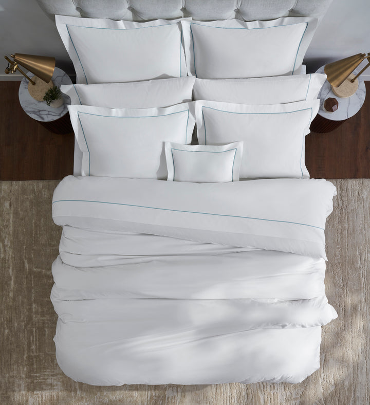 DT-055-10692_3|Crisp white duvet cover with elegant blue trim, neatly arranged on a bed, providing a top-down view of luxurious bedding.