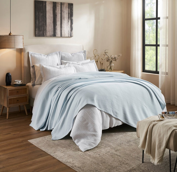 BL-859-9496_2|Light blue waffle weave blanket draped across a bed, adding a serene touch to bedroom decor. Soft, inviting layer.