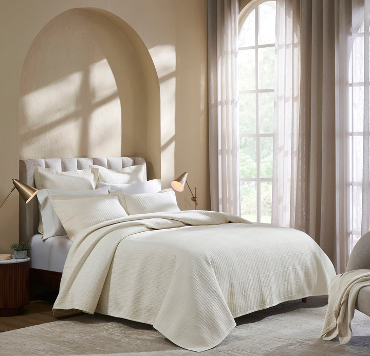 CL-271-11096_1|Luxurious cream textured coverlet gracefully draped on a modern bed, creating a serene and stylish bedroom ambiance. Elegant bedding.