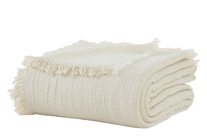 BT-115-9496_2|Beautifully folded cream woven throw blanket, featuring a delicate textured pattern and charming fringed edges.