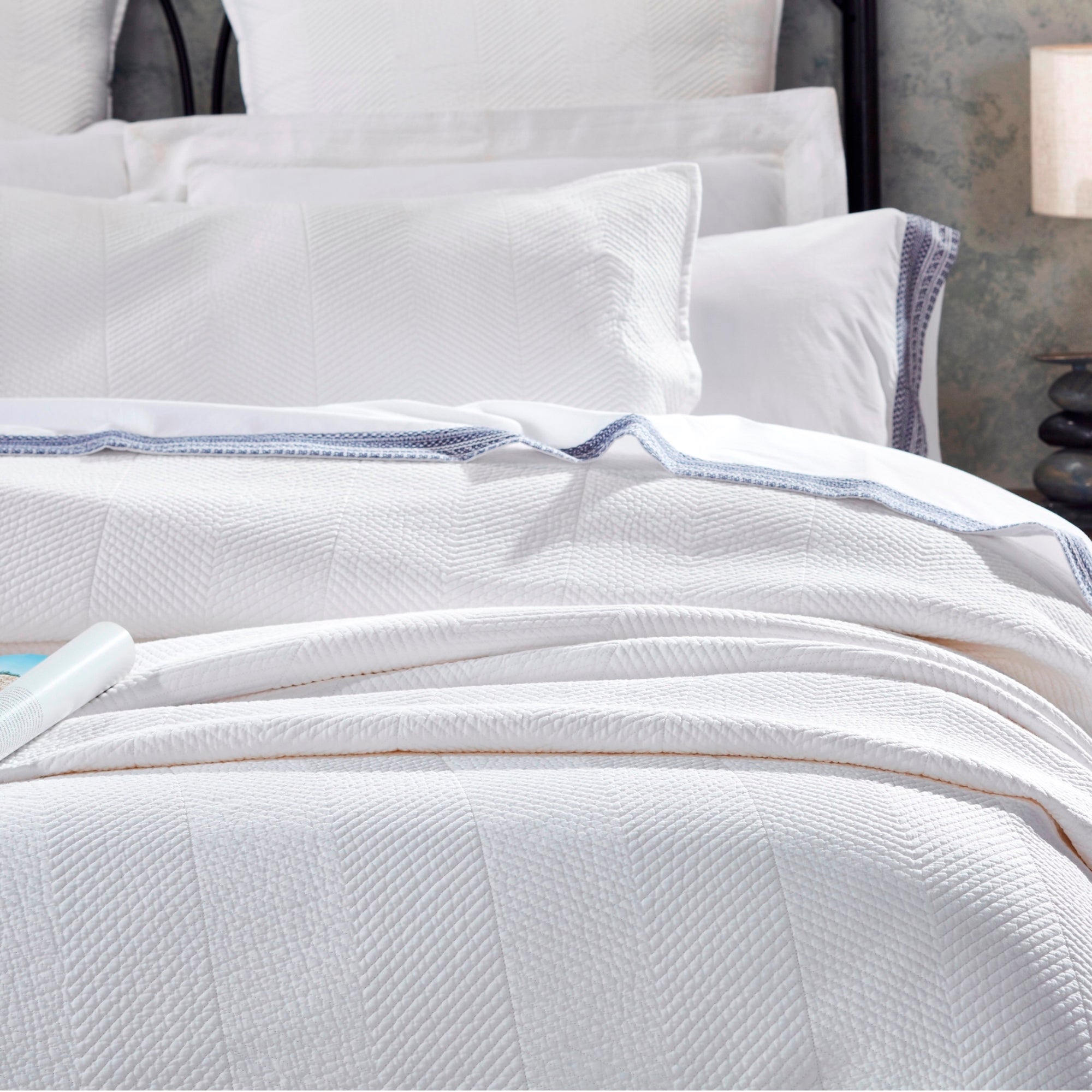 CL-170-11096_4|Close-up of elegant white chevron woven coverlet on a plush bed, showcasing its textured pattern and sophisticated design.
